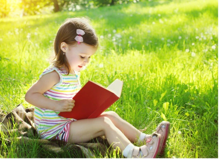 young girl reading outside